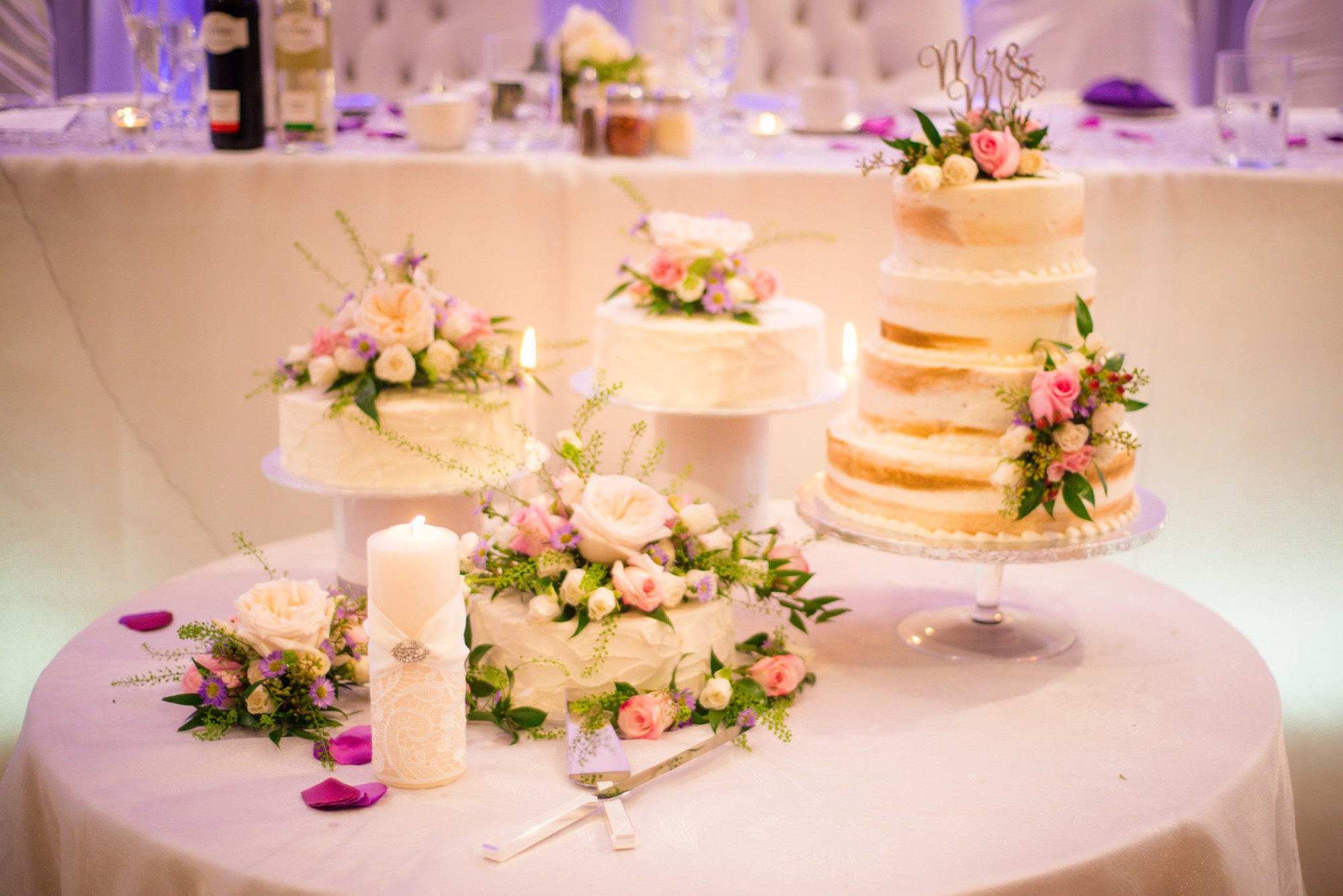 Tiered wedding cake and floral reception decorations