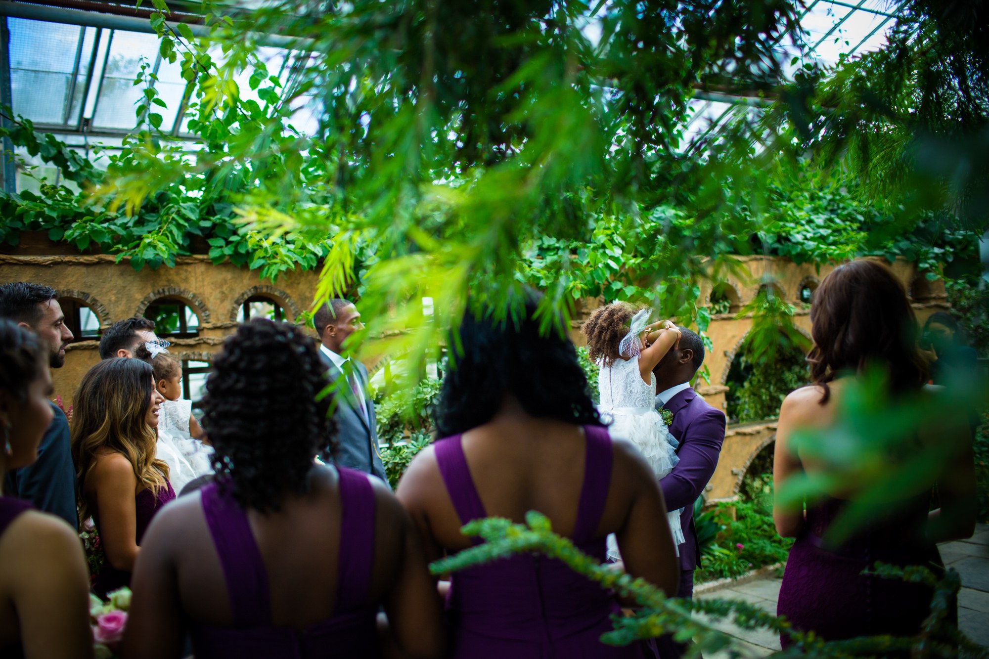 Guests watching a ceremony surrounded by greenery