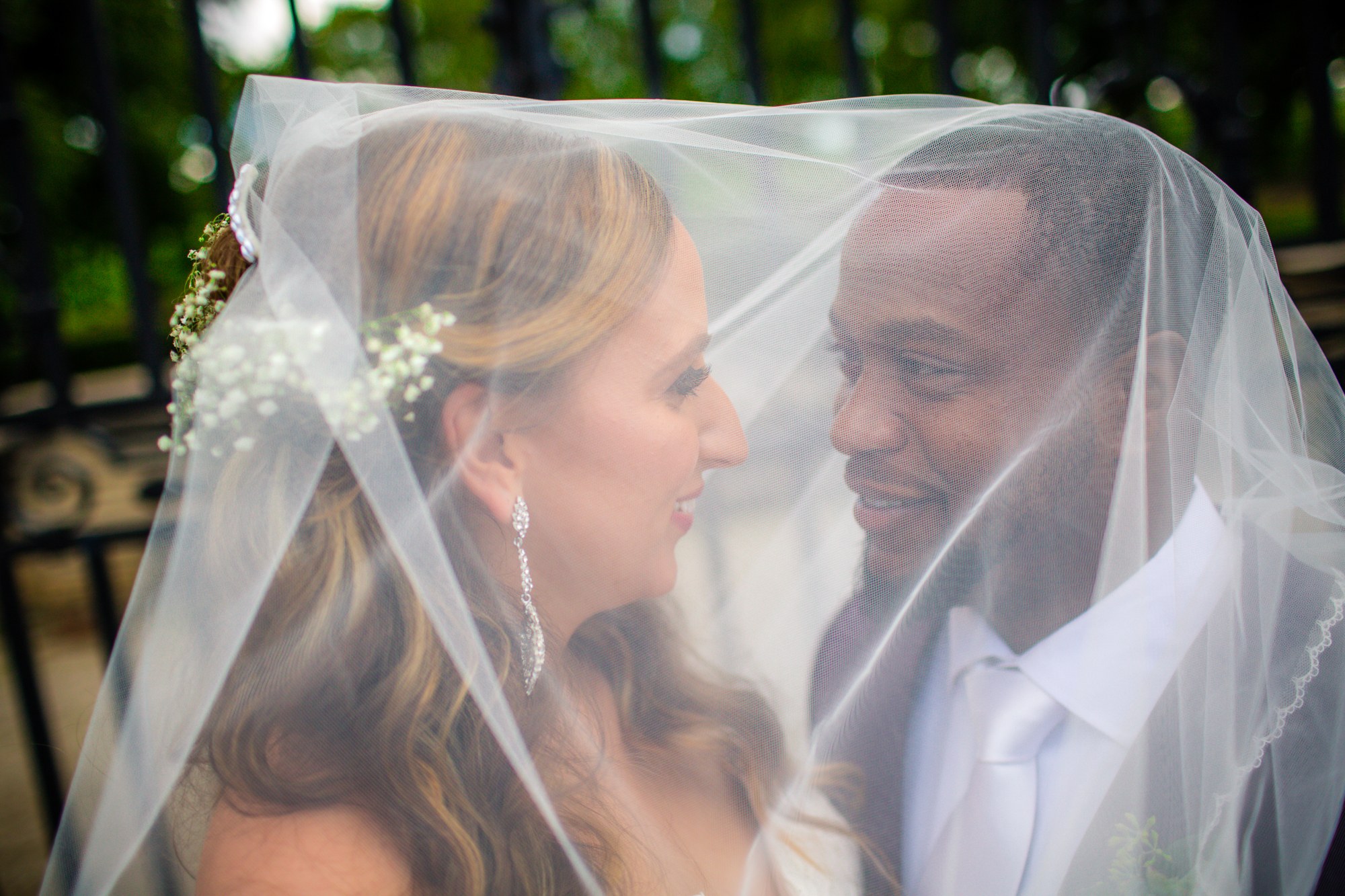 Newlyweds sharing a quiet moment beneath a veil