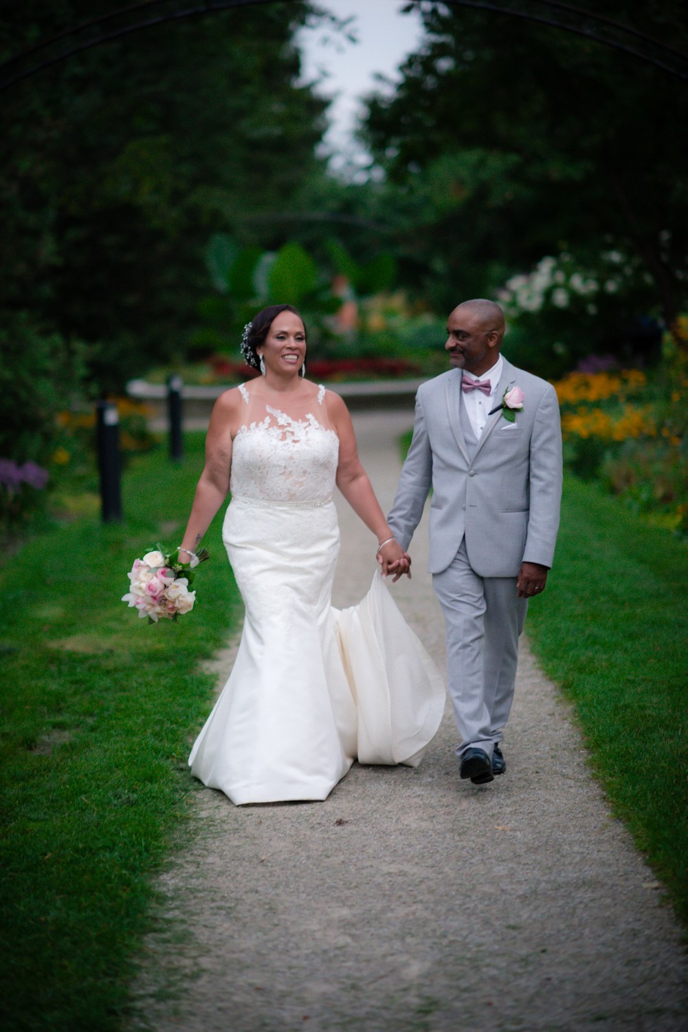 Couple walking along a tree-lined garden path