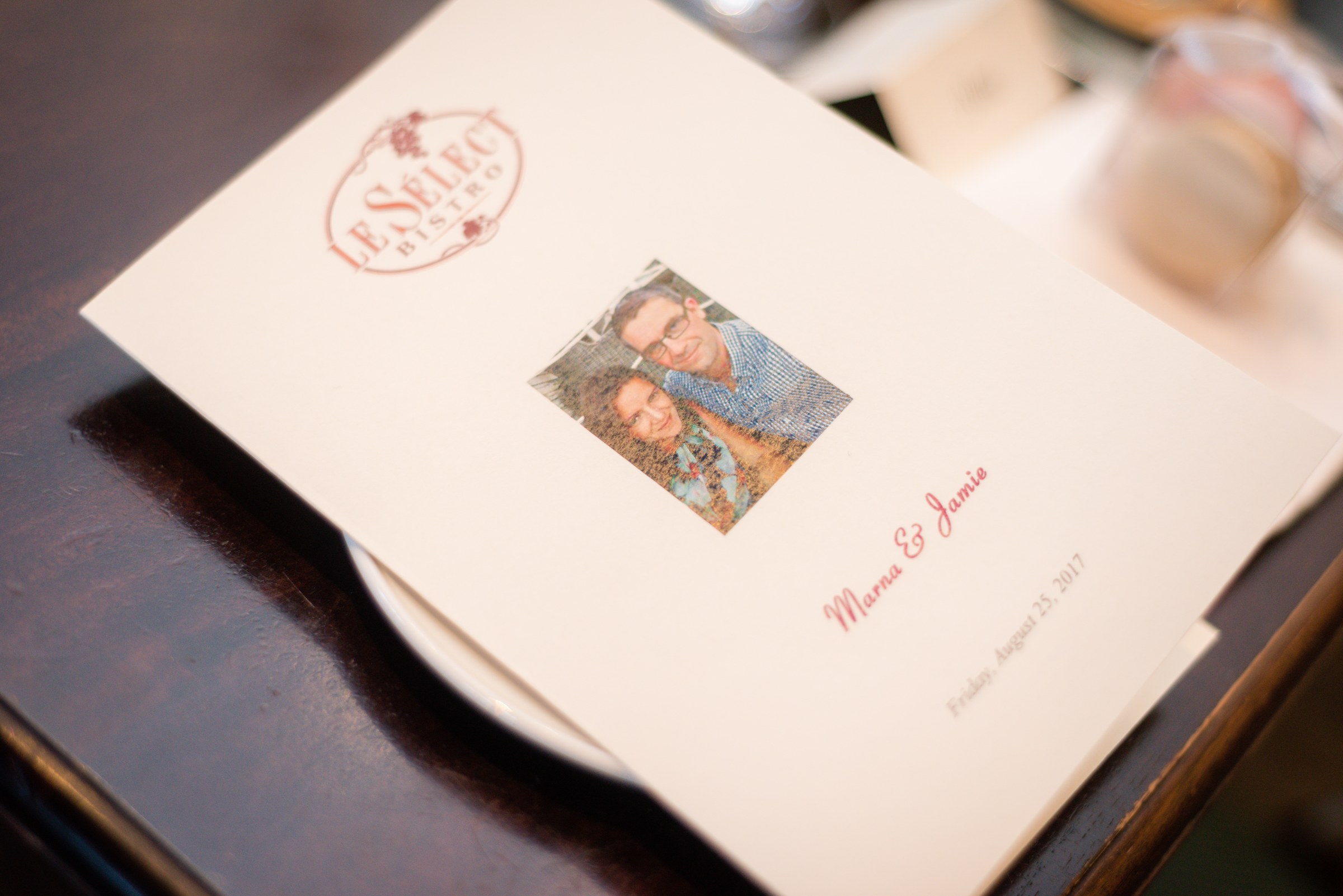Wedding stationery and a guest book on a wooden table