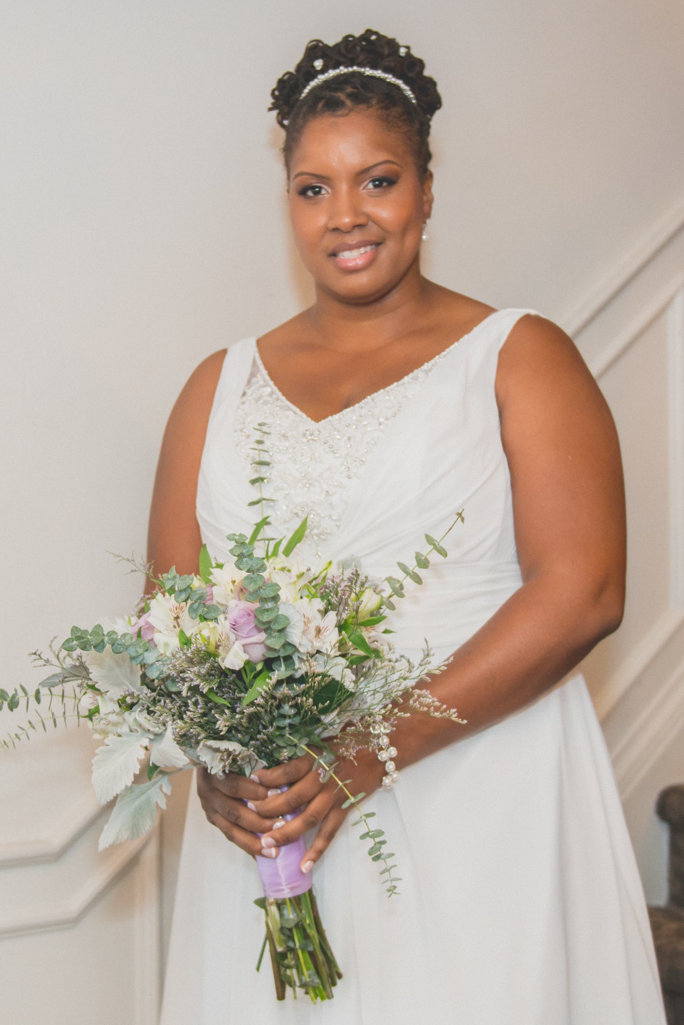 Bride holding her bouquet at the top of a staircase