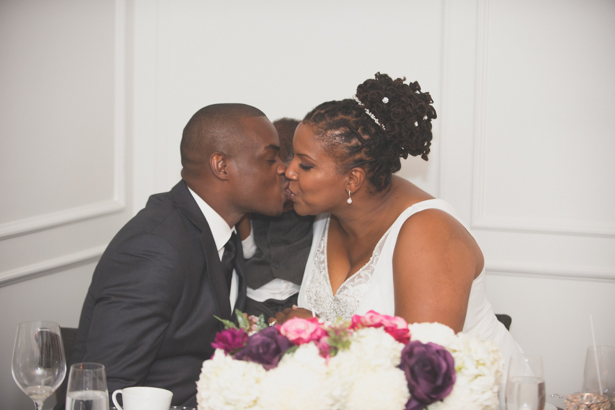 Couple sharing a kiss at their reception table