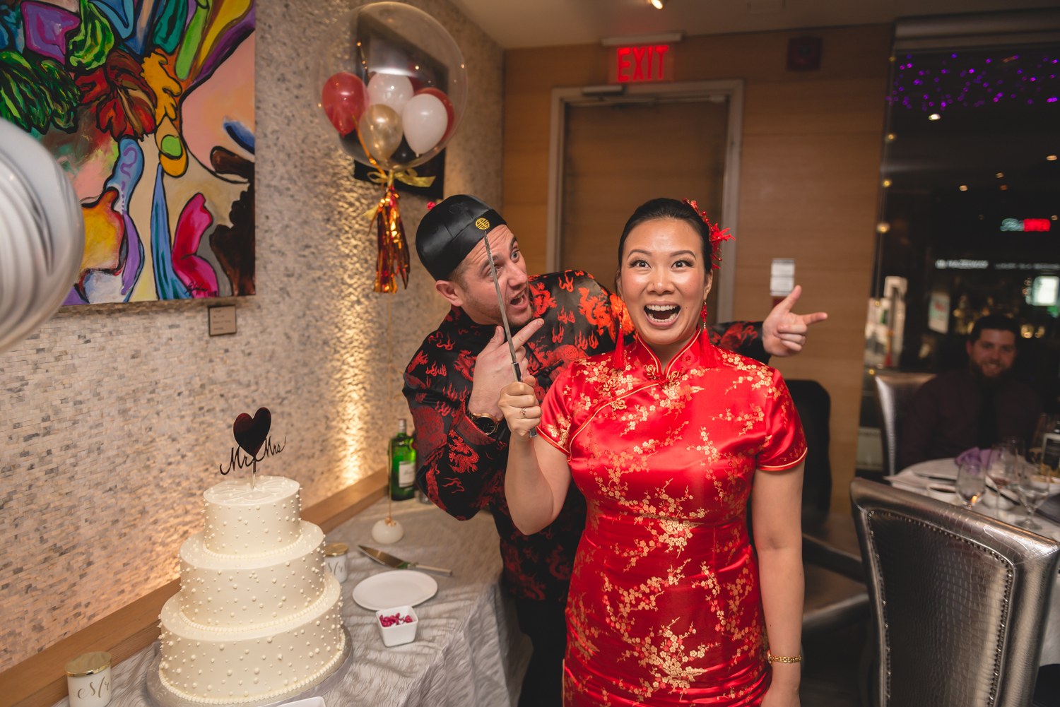 Couple laughing together beside their celebration cake